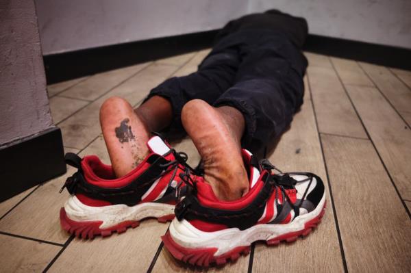 A man sleeping on the floor of an ATM vestibule in The Hub on Aug. 29, 2024.