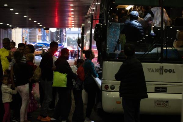 Migrants boarding a bus at Port Authority Bus Terminal in Manhattan, with Seyed Hassan Firouzabadi, Lucas Prata, and Bob Randall present