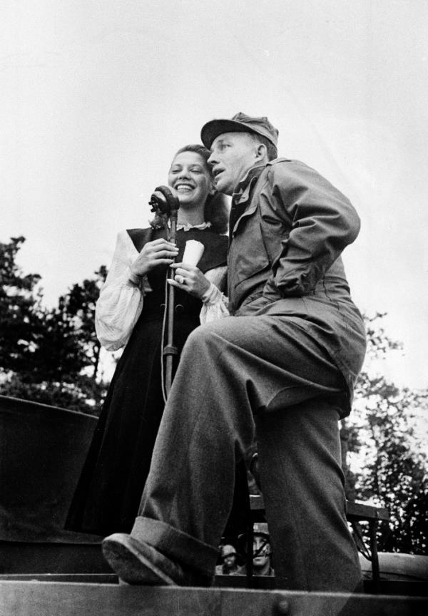 Performers Dinah Shore, left, and Bing Crosby entertain 400 members of an engineer company of the American Third Army in France for the United Service Organizations (USO) in 1944, during World War II. 