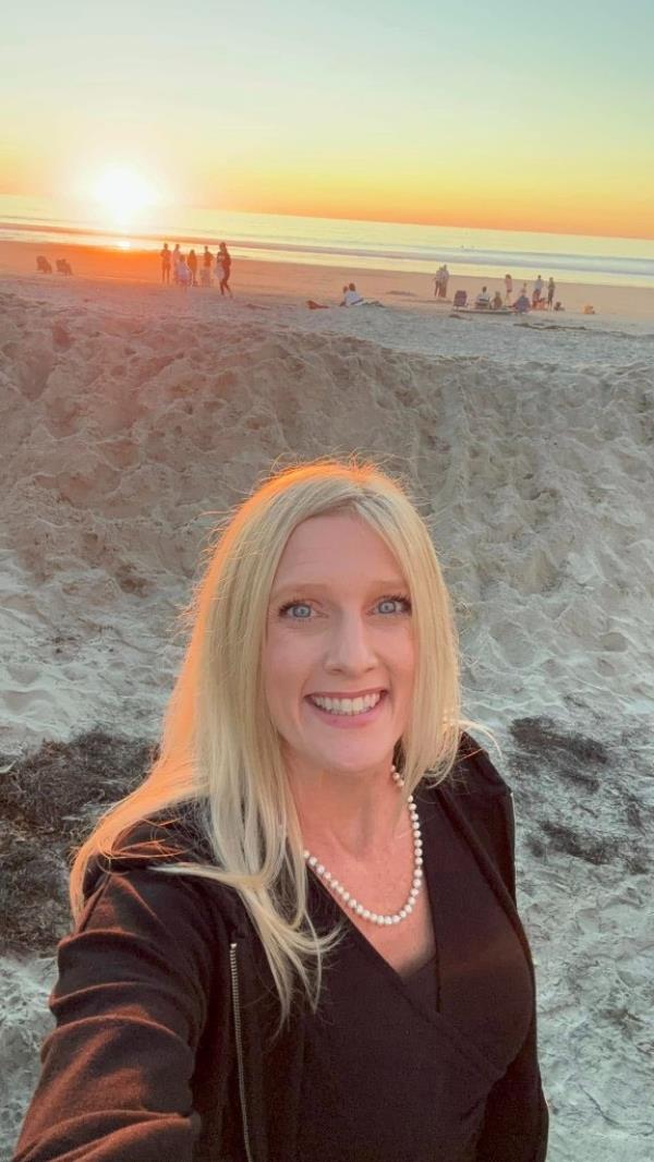 smiling selfie of Erin Quinn taken on a beach