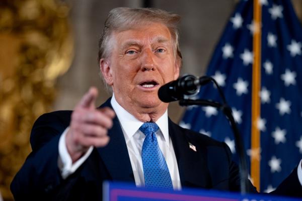 President-elect Do<em></em>nald Trump addressing the press at Mar-a-Lago resort, pointing at a microphone.