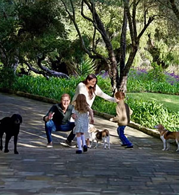 Prince Harry and Meghan Markle are seen surrounded by their three dogs -- Pula, Guy and Momma Mia -- as their children, Prince Archie and Princess Lilibet, run up to hug them in a photo featured on the Duke and Duchess of Sussex's 2024 Christmas card.