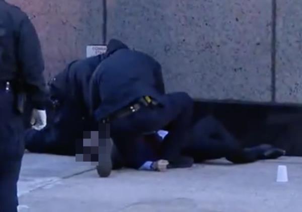 A man in a black suit at the scene of a shooting near W. 54th St. and 6th Avenue outside the Hilton Hotel.