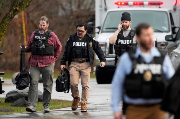 Police walk outside the Abundant Life Christian School following a shooting, Monday, Dec. 16, 2024 in Madison, Wis. 