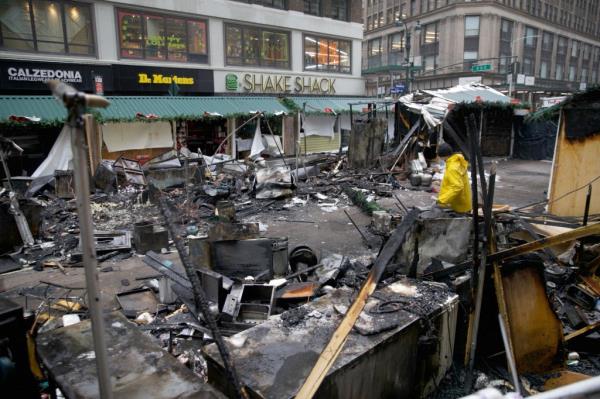 Firefighters work at the scene of a fire at the Christmas Market in Herald Square on Broadway and 35th St early Monday, Dec. 16, 2024.