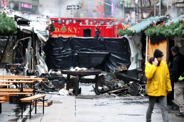 Firefighters work at the scene of a fire at the Christmas Market in Herald Square on Broadway and 35th St early Monday, Dec. 16, 2024.