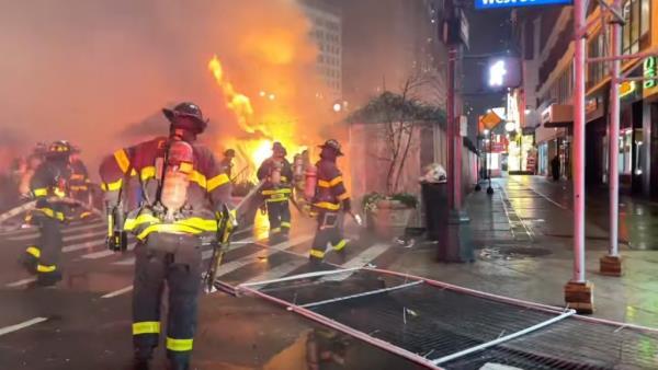 Firefighters work at the scene of a fire at the Christmas Market in Herald Square on Broadway and 35th St early Monday, Dec. 16, 2024.