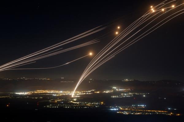 Rockets fired from southern Lebanon are intercepted by Israel's Iron Dome air defence system over the Upper Galilee region in northern Israel, on August 4, 2024