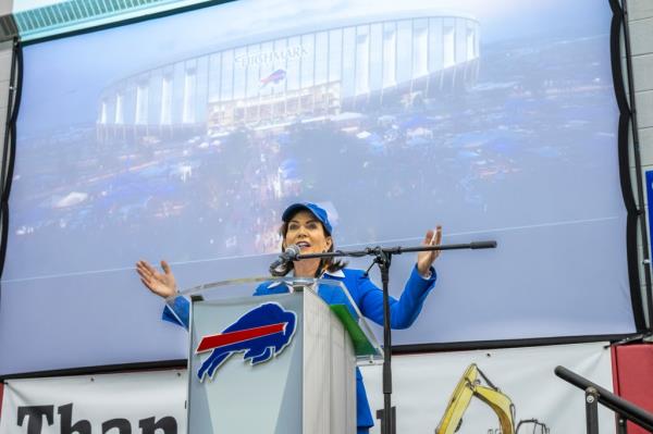 Hochul in front of a podium with the rendering of the new Bills stadium behind her.