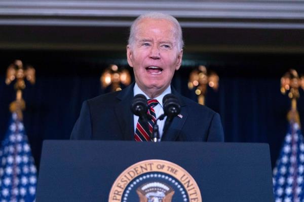 President Joe Biden delivering remarks at the Democratic Natio<em></em>nal Committee's Holiday Reception, standing at a podium