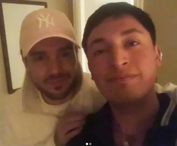 Liam Payne and an Argentinian waiter taking a selfie in a hotel room