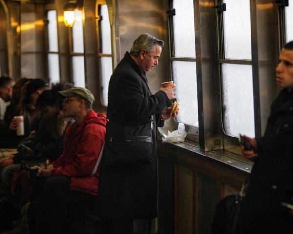 A passenger drinks coffee aboard a Staten Island Ferry